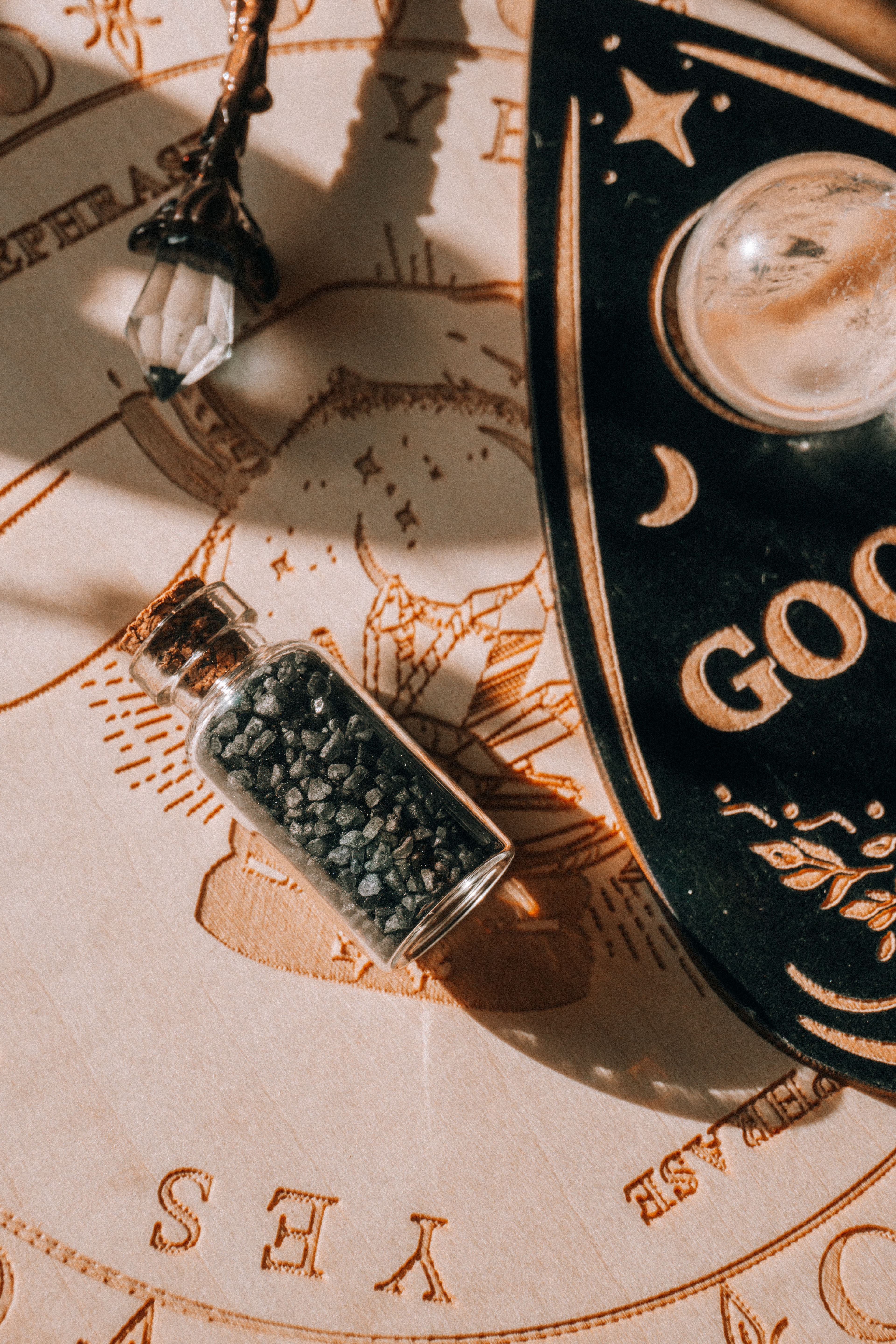 A talking board and small jar on a warm patterned cloth