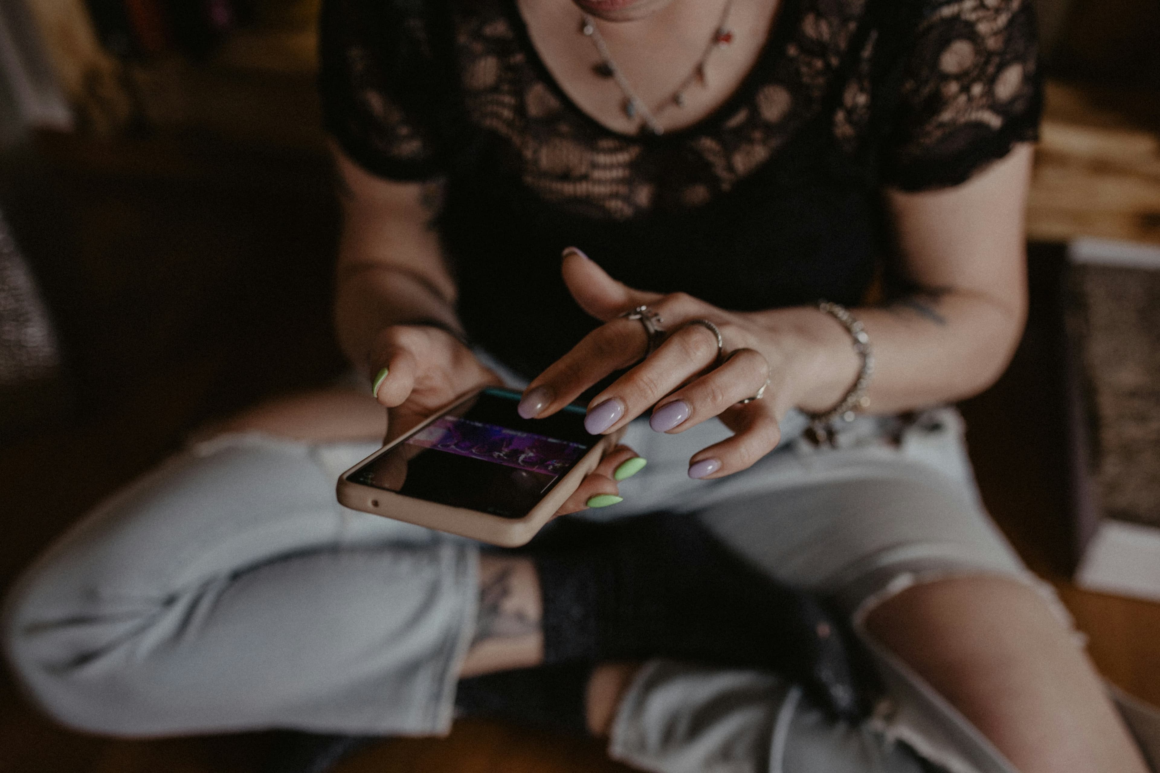A reader looking at a phone while seated