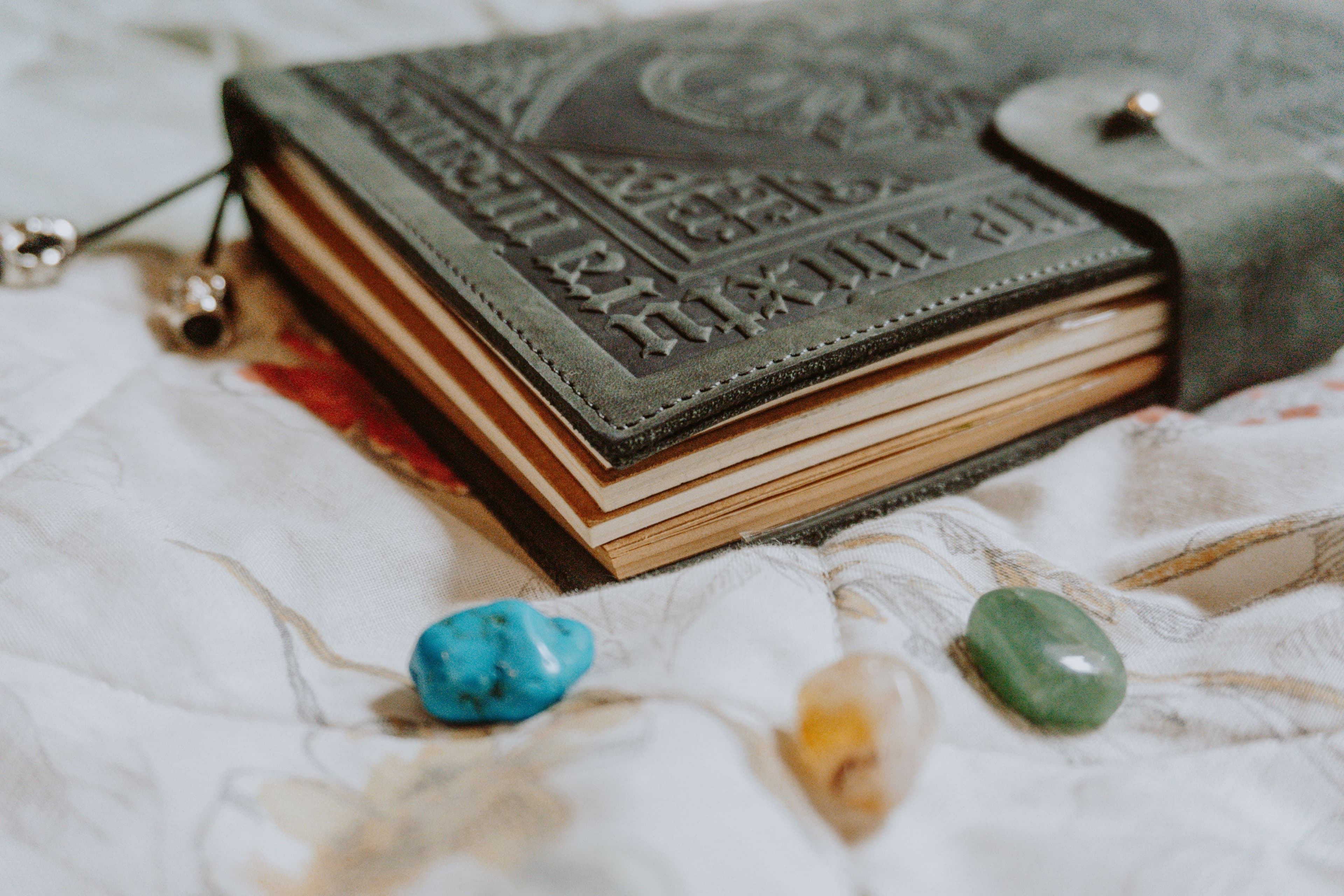 A reader's tarot workspace with cards, a laptop, and a notebook